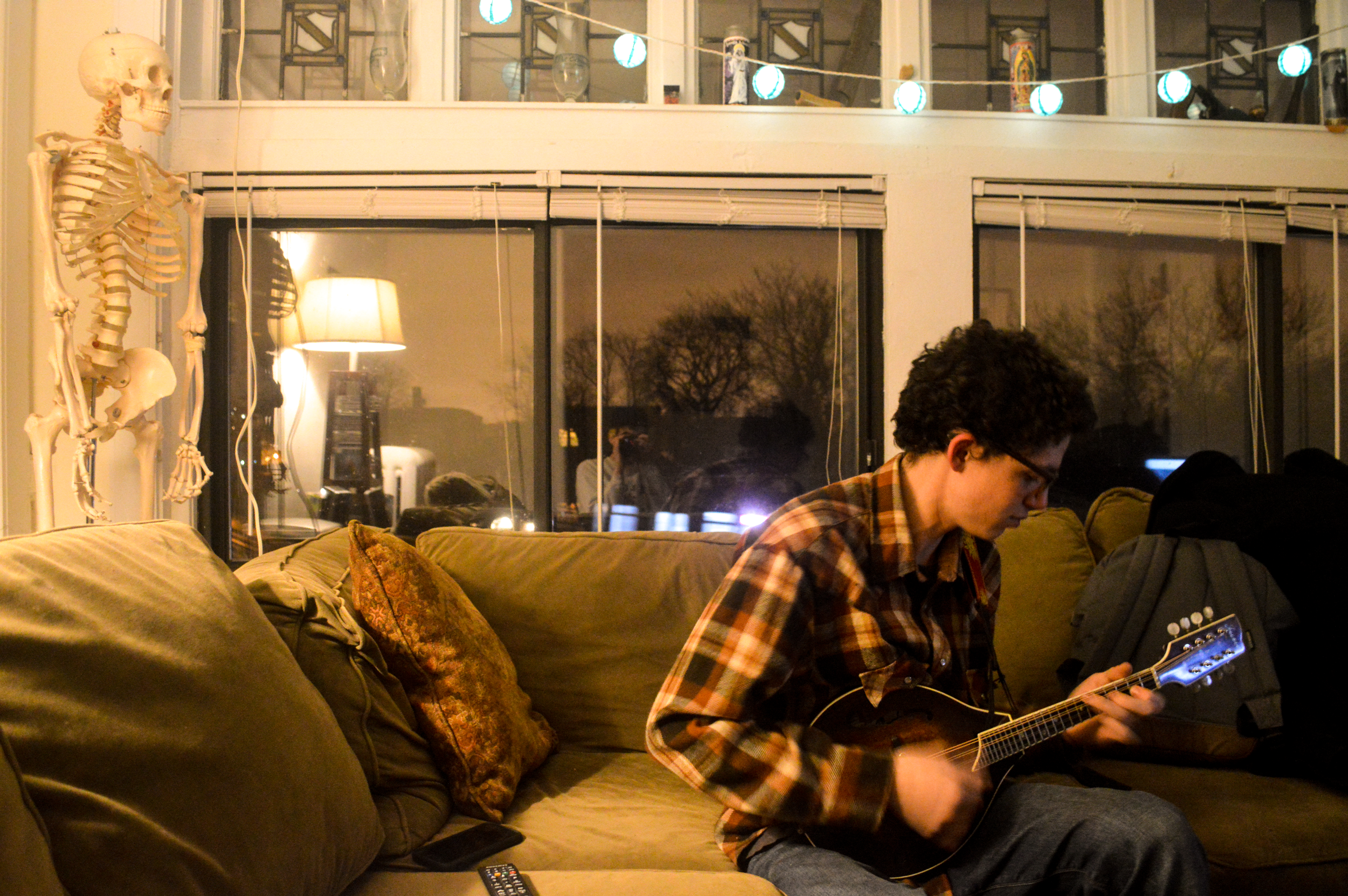 Sam Kunkel plays a mandolin in his apartment (Michael Schmidt, 14 East Magazine)